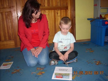 wychowawczyni siedzi z chłopcem na dywanie