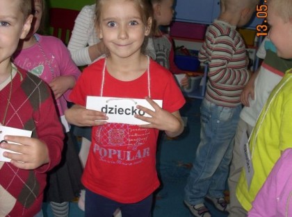 dzieci z tabliczkami na szyi w przedszkolu