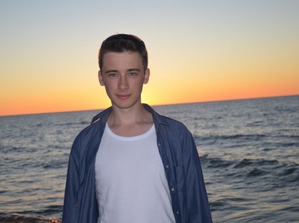 młody człowiek na tle morza w niebieskiej koszuli